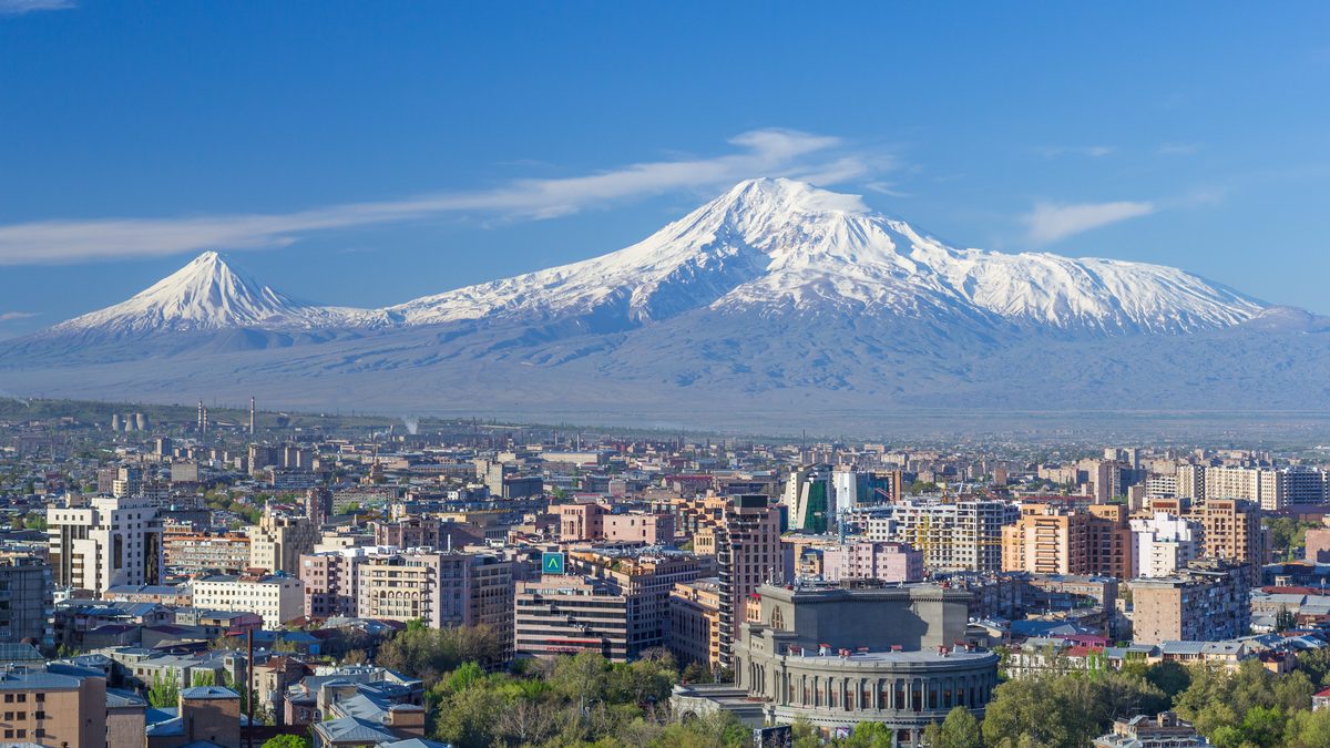Mount Ararat rising behind the Yerevan skyline in spring, with the Armenian Opera House in the foreground